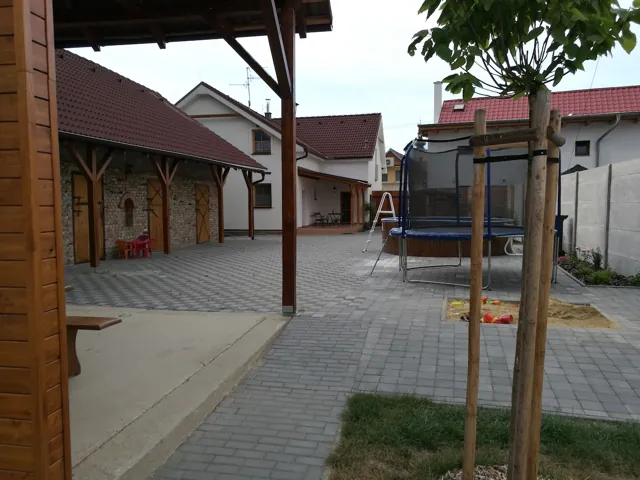Dvůr s trampolínou a pohledem na chalupu